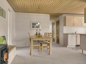 een keuken en eetkamer met een houten tafel en stoelen bij Holiday Home Undine - 300m from the sea in Funen by Interhome in Middelfart