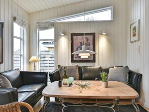 uma sala de estar com um sofá e uma mesa em Holiday Home Viljami - 20m from the sea in Funen by Interhome em Nyborg