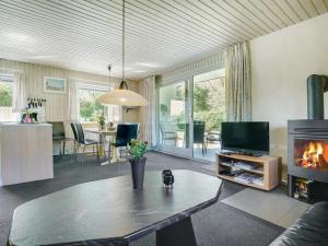 a living room with a table and a fireplace at Holiday Home Suni - 400m from the sea in Funen by Interhome in Middelfart