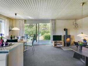 a kitchen and living room with a table and a fireplace at Holiday Home Suni - 400m from the sea in Funen by Interhome in Middelfart
