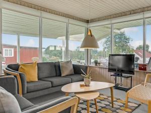 uma sala de estar com um sofá e uma televisão em Holiday Home Fita - 300m from the sea in Funen by Interhome em Asperup