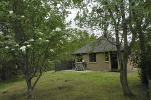 a small house with a table and chairs in a yard at Falcon Lodge in Aviemore