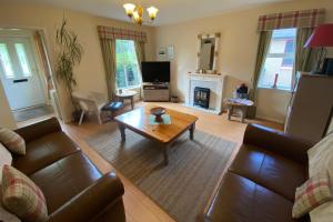 a living room with a couch and a coffee table at Falcon Lodge in Aviemore