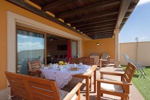 comedor con mesa y algunas sillas en Villa Carmen, en Caleta de Fuste