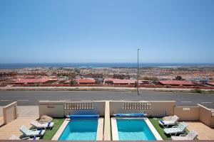 - Vistas a 2 piscinas de un edificio en Villa Carmen, en Caleta de Fuste