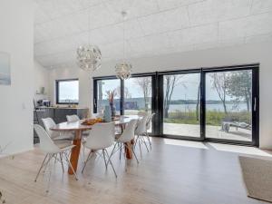 comedor con mesa y sillas blancas en Holiday Home Haley - 150m from the sea in Funen by Interhome, en Millinge