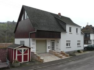 una casa bianca con un garage rosso e bianco di Ferienwohnungen Bei Anne a Saarburg