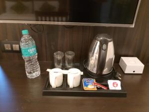 a black tray with a coffee maker and a bottle of water at Hotel Greenlife in Cochin
