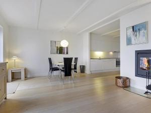 a white living room with a table and chairs at Apartment Terina - 5m from the sea in Funen by Interhome in Bagenkop