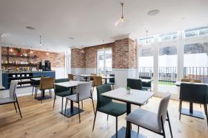 een restaurant met tafels, stoelen en ramen bij 55 by Le Mirage in Londen
