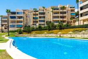 a swimming pool with apartment buildings in the background at Lovely flat in Casinomar - Torrequebrada Ref 114 in Benalmádena