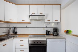 cocina con armarios blancos y fogones en Lovely flat in Casinomar - Torrequebrada Ref 114, en Benalmádena
