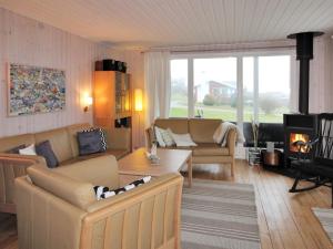uma sala de estar com dois sofás e uma lareira em Holiday Home Arton - 300m from the sea in Funen by Interhome em Ebberup