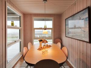 uma sala de jantar com uma mesa de madeira e cadeiras em Holiday Home Arton - 300m from the sea in Funen by Interhome em Ebberup