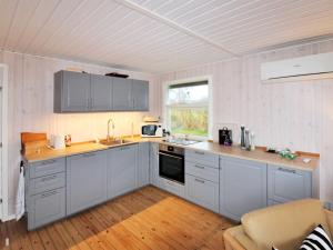 kuchnia z szarymi szafkami, umywalką i oknem w obiekcie Holiday Home Arton - 300m from the sea in Funen by Interhome w mieście Ebberup