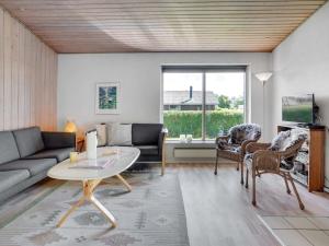 uma sala de estar com um sofá e uma mesa em Holiday Home Ilppo - 200m from the sea in Funen by Interhome em Hesselager