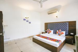 a bedroom with a large bed with colorful pillows at FabExpress Llyod House in New Delhi