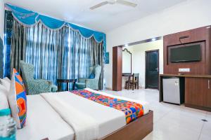 a hotel room with a bed and a flat screen tv at FabExpress Llyod House in New Delhi