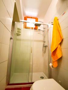 bagno con doccia, servizi igienici e asciugamani gialli di Casa Aiello a Camigliatello Silano