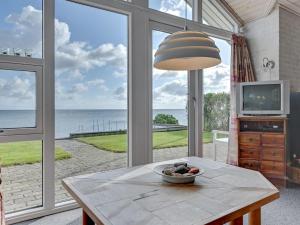 salon ze stołem i widokiem na ocean w obiekcie Holiday Home Keti - 5m from the sea in Funen by Interhome w mieście Nyborg