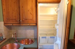 a kitchen with two sinks and an open refrigerator at Villa Sorriso in Ponte di Legno +45 photos