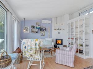 sala de estar con sillas, mesa y chimenea en Holiday Home Daike - 25m from the sea in Funen by Interhome, en Bogentved
