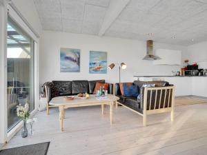 een woonkamer met een bank en een tafel bij Holiday Home Käthe - 5m from the sea in Funen by Interhome in Middelfart