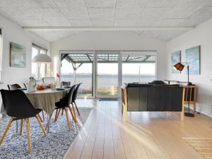 een woonkamer met een tafel en stoelen en een eetkamer bij Holiday Home Käthe - 5m from the sea in Funen by Interhome in Middelfart