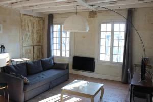 a living room with a couch and a table at Charmant Duplex Rue Colbert in Tours