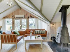 sala de estar con sofá y chimenea en Holiday Home Hjalmine - 250m from the sea in Funen by Interhome en Assens