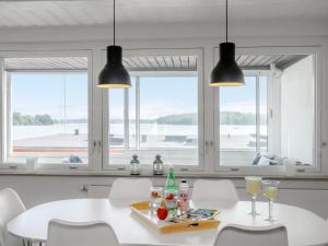 a dining room with a table and chairs and windows at Apartment Constance - 50m from the sea in Funen by Interhome in Svendborg