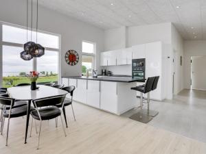 a kitchen with white cabinets and a table and chairs at Holiday Home Constantin - 500m from the sea in SE Jutland by Interhome in Sjølund