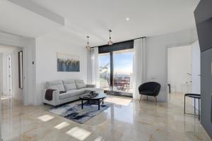 un soggiorno bianco con divano e tavolo di Modern, elite hillside home w/sea & mountain views a Marbella