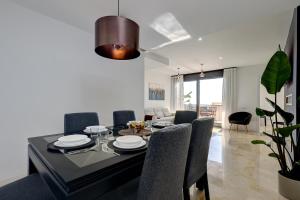 una sala da pranzo con tavolo e sedie di Modern, elite hillside home w/sea & mountain views a Marbella