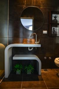 ein Badezimmer mit einem Waschbecken, einem Spiegel und Pflanzen in der Unterkunft Ambit Boulevard Hotel Boutique in Santa Fe