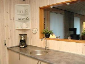 een aanrecht met een wastafel en een spiegel bij Holiday Home Jarmunrek - 1km from the sea in SE Jutland by Interhome in Hejls