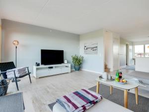 een woonkamer met een flatscreen-tv aan een witte muur bij Apartment Lucjan - 50m from the sea in Funen by Interhome in Assens