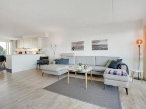 een woonkamer met een bank en een tafel bij Apartment Lucjan - 50m from the sea in Funen by Interhome in Assens