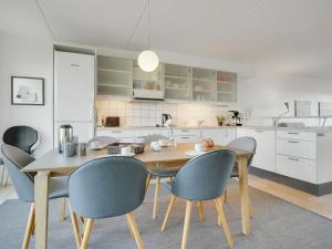 een keuken met een houten tafel en stoelen bij Apartment Lucjan - 50m from the sea in Funen by Interhome in Assens