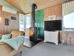 sala de estar con chimenea y TV en Holiday Home Nnykka - 100m from the sea in Funen by Interhome, en Bøjden