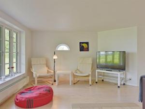 un soggiorno con TV a schermo piatto e sedie di Holiday Home Ansbert - 150m from the sea in Funen by Interhome ad Assens