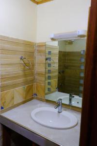 a bathroom with a sink and a mirror at Khalisee Homes Studio apartment in Voi