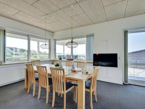 een eetkamer met een tafel en stoelen en een tv bij Apartment Irma - 25m from the sea in Funen by Interhome in Tranekær
