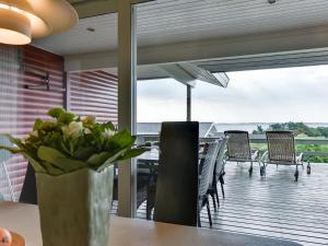 a dining room with a table with a vase of flowers at Holiday Home Miriam - 300m from the sea in Funen by Interhome in Ebberup