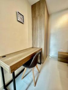 a wooden desk with a chair in a room at Kuching Kozi Square Apartment in Kuching