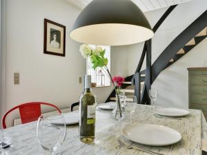 a dining room with a table with a bottle of wine at Holiday Home Gunhilda - 200m from the sea in Funen by Interhome in Spodsbjerg