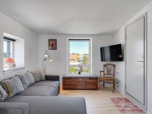 a living room with a couch and a flat screen tv at Apartment Axlan - 50m from the sea in Funen by Interhome in Tranekær