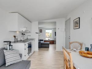 a kitchen and living room with a table and a dining room at Apartment Axlan - 50m from the sea in Funen by Interhome in Tranekær