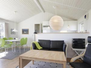 een woonkamer met een bank en een tafel bij Holiday Home Bridgette - 100m from the sea in Funen by Interhome in Tranekær