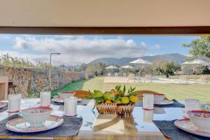 una mesa con platos y tazones de fruta. en Villa Son Guinyol by Slow Villas, en Alaró